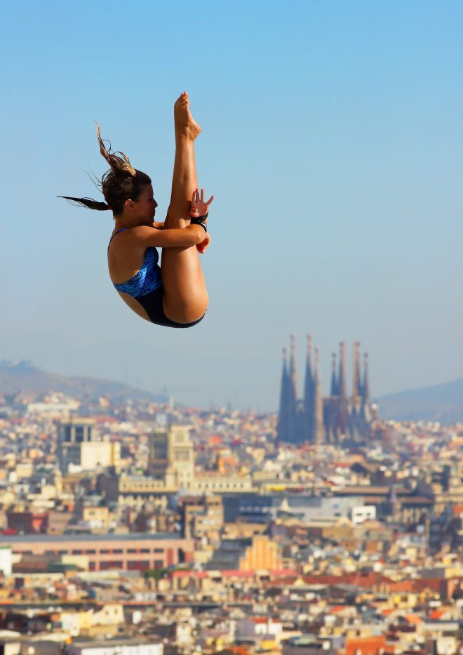 imatge d'una saltadora a les piscines Picornell amb la Sagrada Familia al fons